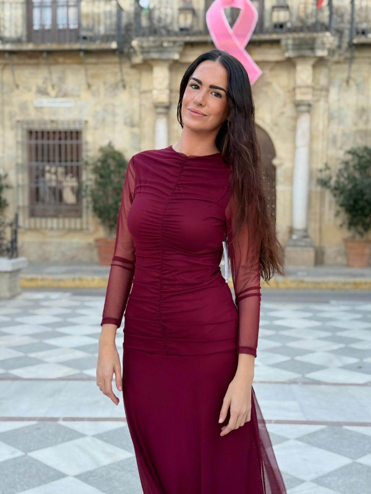 Mujer con vestido midi de tul color burdeos y fruncido delantero