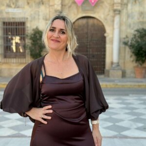 Mujer con vestido satinado color chocolate y capa de gasa, escote recto