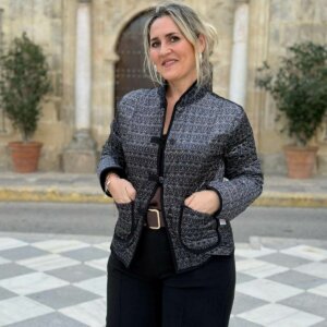 Primer plano de los bolsillos ribeteados en chaqueta negra con dibujo geométrico