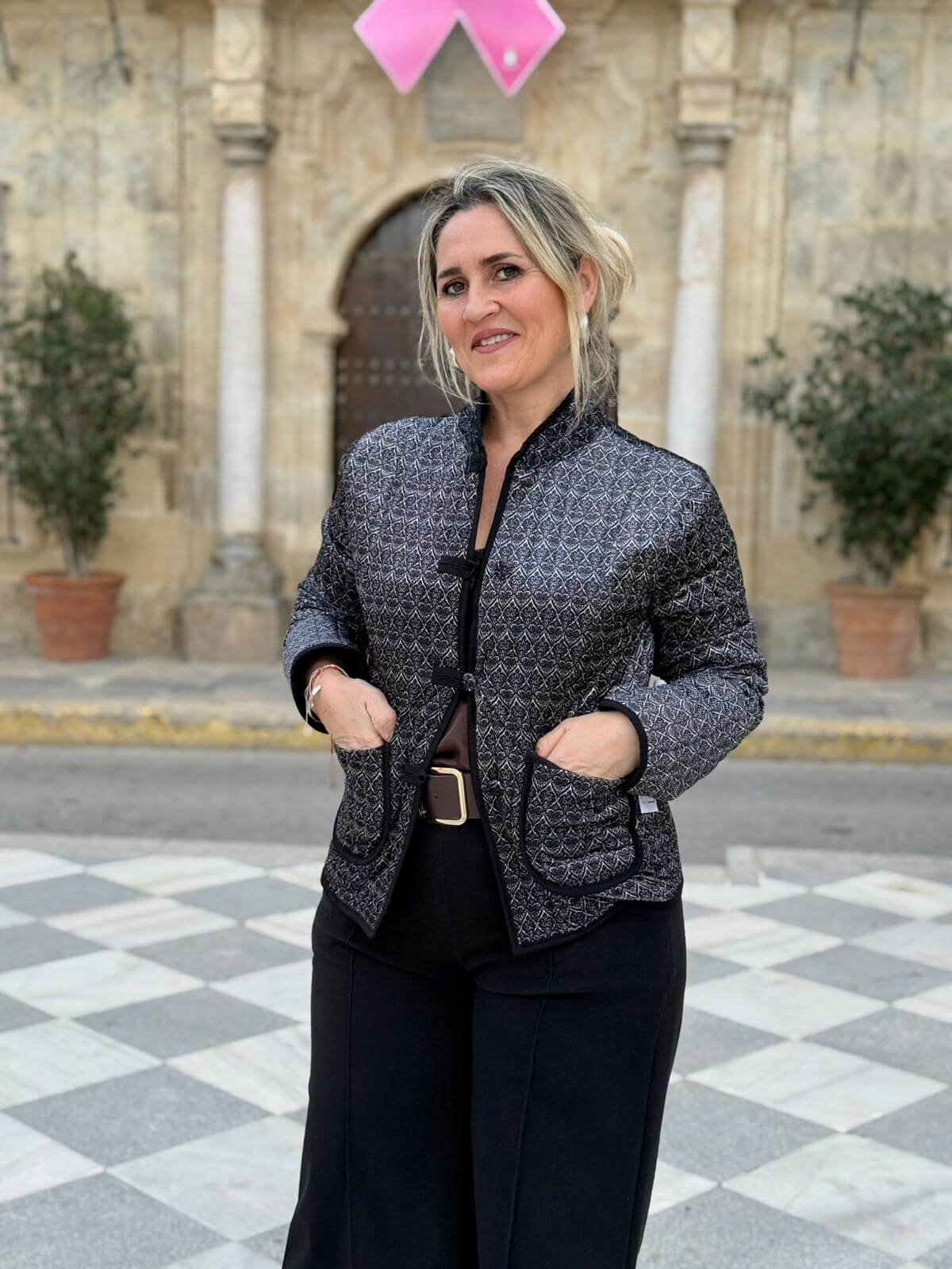 Primer plano de los bolsillos ribeteados en chaqueta negra con dibujo geométrico